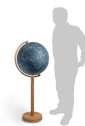 figure standing next to 19 inch floor standing globe in blue and copper showing clipper sailing routes