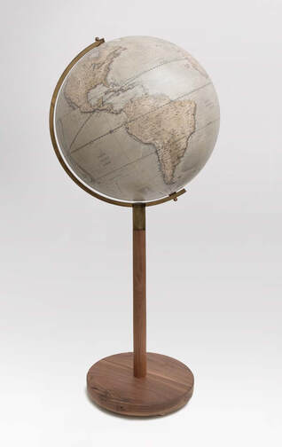 a large library globe on a walnut stand. Green coloured and it shows South America