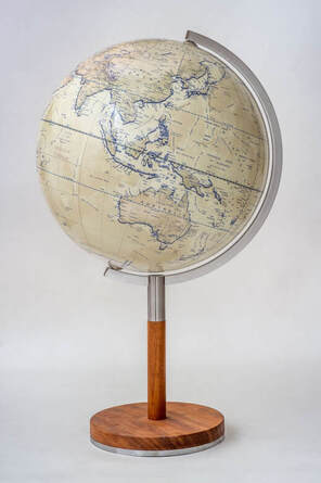 Nordic globe showing Australia. Light coloured contemporary modern globe on wooden stand