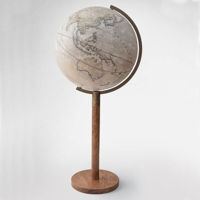 large globe sitting on a tall elegant slender base with aged brass arm