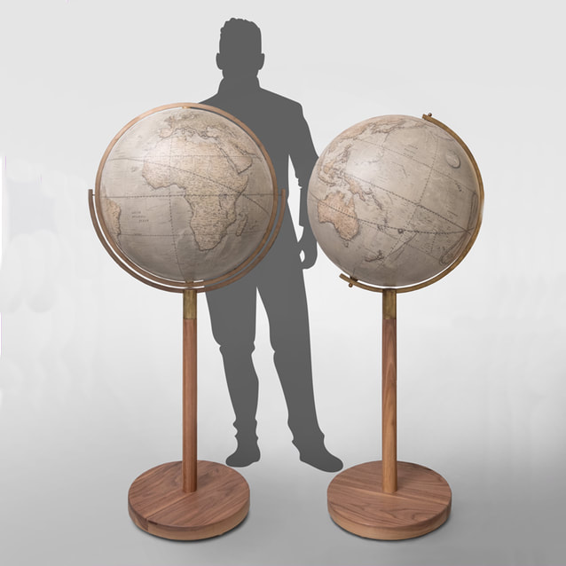 two large globes on tall stems with a silhouette of a man standing behind them for scale 
